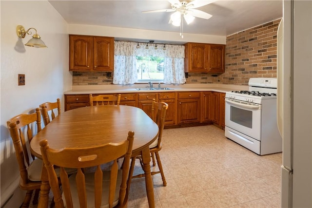 2509 Spring St, Arlington, PA 15210 - kitchen with white appliances, brown cabinets, ceiling fan, and light countertops