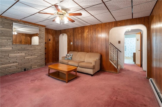 2509 Spring St, Arlington, PA 15210 - living room featuring arched walkways, a baseboard radiator, carpet floors, wooden walls, and a ceiling fan