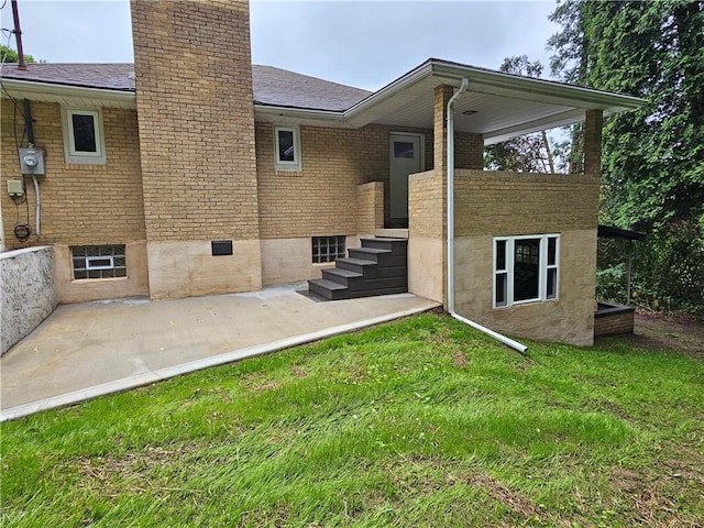 946 Herman Rd, Summit Twp But, PA 16002 - back of property with a chimney, a yard, brick siding, and roof with shingles