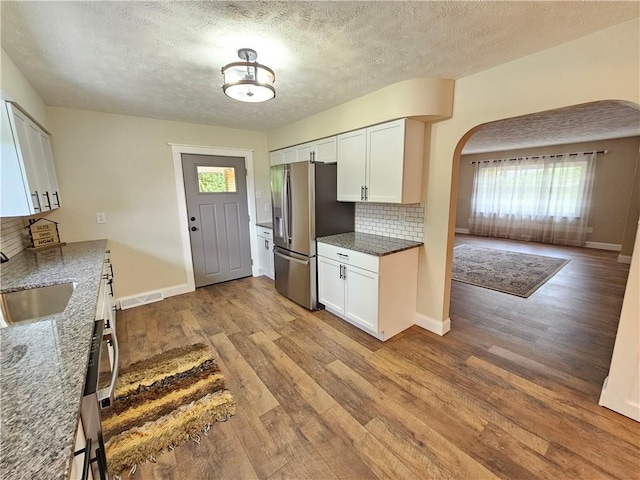 946 Herman Rd, Summit Twp But, PA 16002 - kitchen featuring stainless steel refrigerator with ice dispenser, tasteful backsplash, plenty of natural light, wood finished floors, and a textured ceiling
