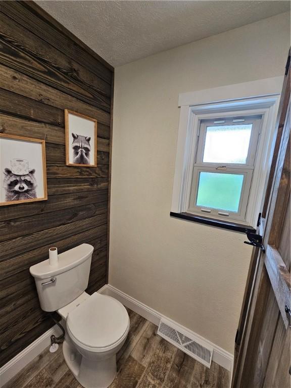 946 Herman Rd, Summit Twp But, PA 16002 - bathroom with wood walls, wood finished floors, and a textured ceiling