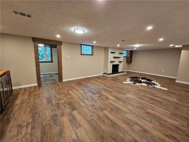 946 Herman Rd, Summit Twp But, PA 16002 - unfurnished living room featuring dark wood-type flooring, a brick fireplace, recessed lighting, and a textured ceiling