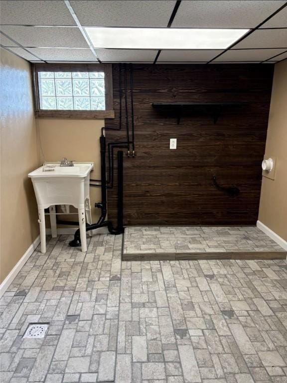 946 Herman Rd, Summit Twp But, PA 16002 - basement featuring a drop ceiling, wooden walls, and brick patterned floors