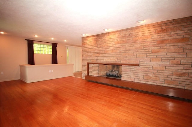 202 Dominican Way, Zelienople Boro, PA 16063 - unfurnished living room featuring a stone fireplace, wood finished floors, and recessed lighting