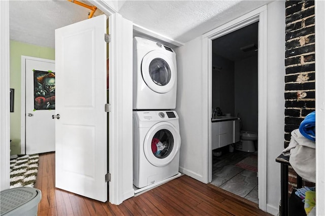 3105 Brereton St, Lawrenceville, PA 15219 - laundry room featuring estacked washer and dryer, dark wood finished floors, and a textured ceiling