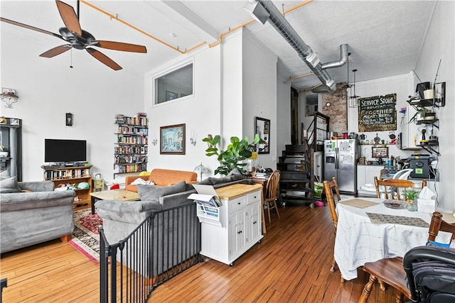 3105 Brereton St, Lawrenceville, PA 15219 - living room featuring a ceiling fan, hardwood / wood-style floors, a towering ceiling, and stairway