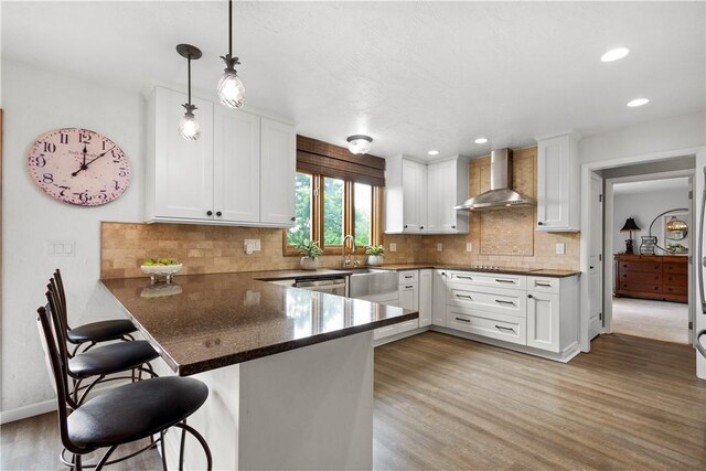 10737 Babcock Blvd, Pine Twp Nal, PA 15044 - kitchen featuring wall chimney range hood, a peninsula, white cabinetry, a kitchen breakfast bar, and light wood finished floors