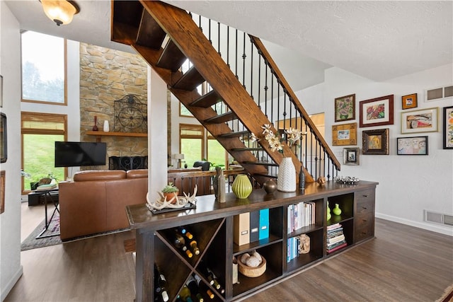 10737 Babcock Blvd, Pine Twp Nal, PA 15044 - bar area featuring wood finished floors, stairs, a towering ceiling, and a fireplace