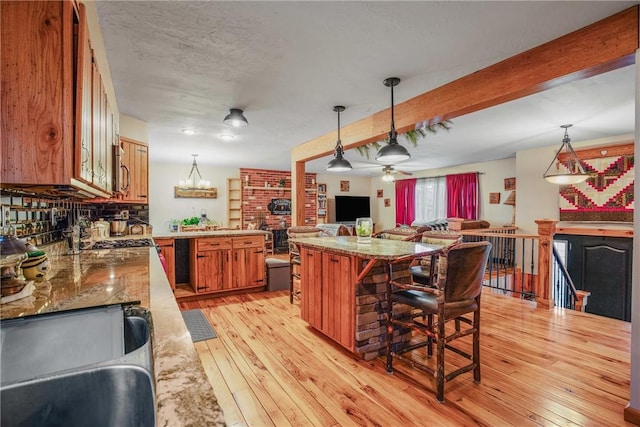 4627 Water Level Rd, Milford Twp, PA 15557 - kitchen featuring brown cabinets, light wood finished floors, beam ceiling, a kitchen breakfast bar, and hanging light fixtures
