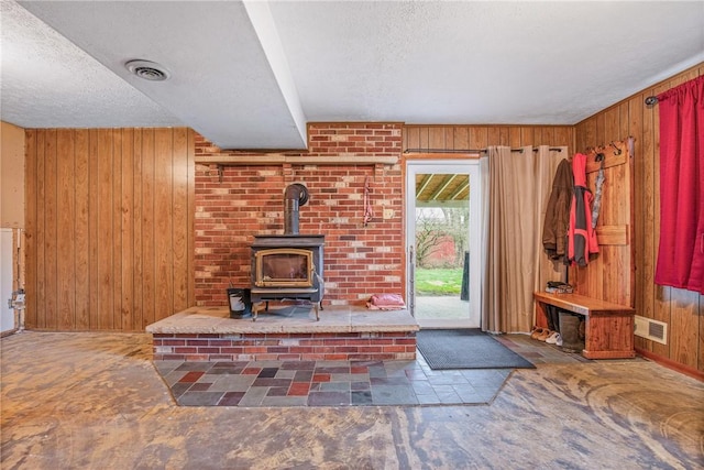 4627 Water Level Rd, Milford Twp, PA 15557 - unfurnished living room featuring a wood stove, wooden walls, and a textured ceiling