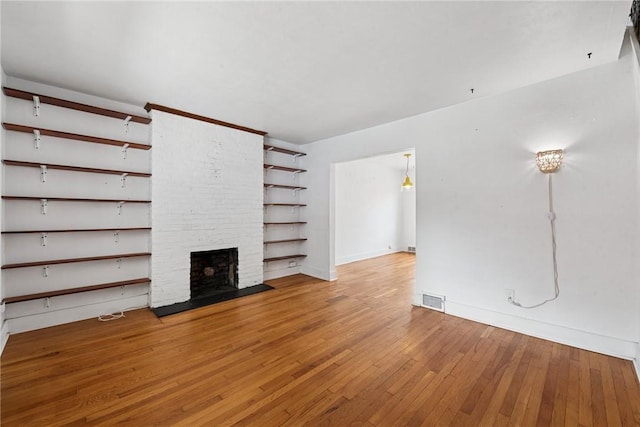 4207 Post St, Lawrenceville, PA 15201 - unfurnished living room featuring wood-type flooring and a brick fireplace