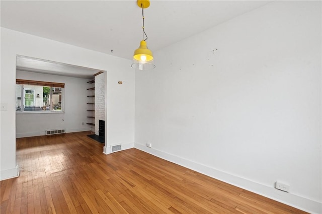 4207 Post St, Lawrenceville, PA 15201 - unfurnished living room with a brick fireplace and wood-type flooring