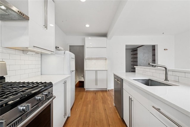 4207 Post St, Lawrenceville, PA 15201 - kitchen featuring stainless steel appliances, wall chimney range hood, backsplash, white cabinets, and recessed lighting