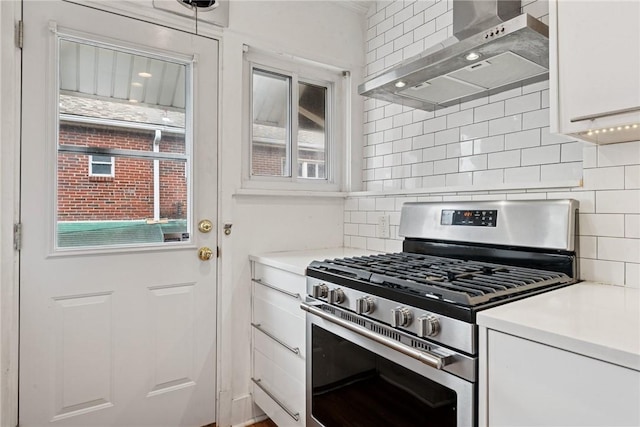 4207 Post St, Lawrenceville, PA 15201 - kitchen with stainless steel range with gas stovetop, wall chimney range hood, white cabinets, light countertops, and decorative backsplash