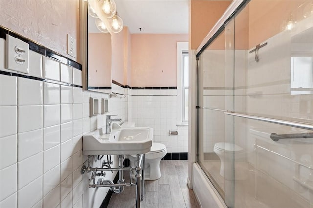 4207 Post St, Lawrenceville, PA 15201 - bathroom with tile walls, enclosed tub / shower combo, wood finished floors, and wainscoting