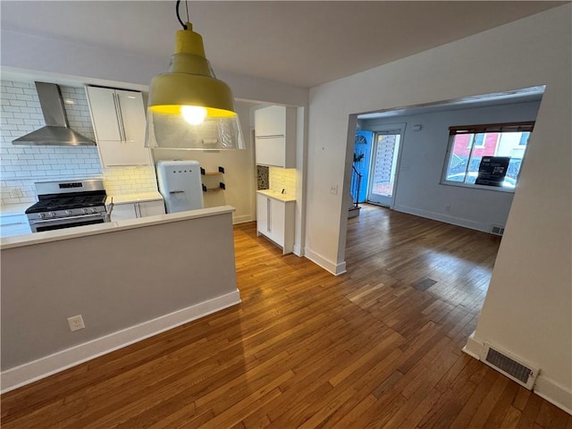 4207 Post St, Lawrenceville, PA 15201 - kitchen featuring stainless steel gas range, wall chimney range hood, decorative backsplash, and wood-type flooring