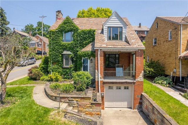2401 Valera Ave, Carrick, PA 15210 - tudor house with brick siding, a garage, a chimney, concrete driveway, and a balcony