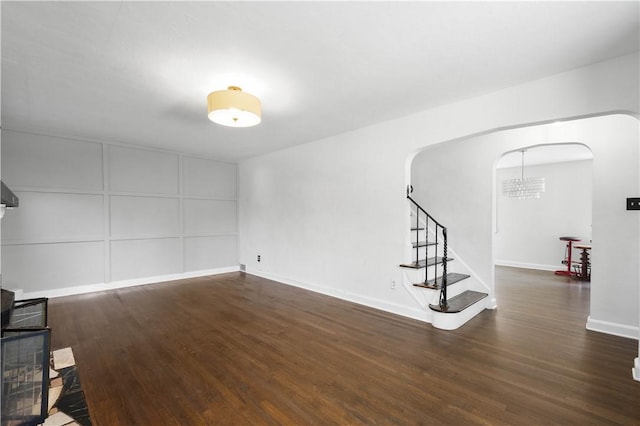 2401 Valera Ave, Carrick, PA 15210 - unfurnished living room with arched walkways, wood finished floors, and stairs