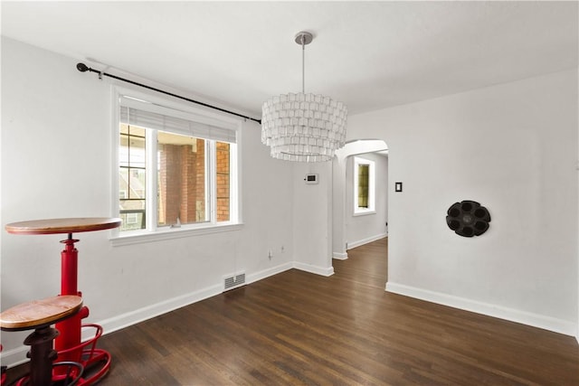 2401 Valera Ave, Carrick, PA 15210 - unfurnished dining area with wood finished floors, arched walkways, and a chandelier