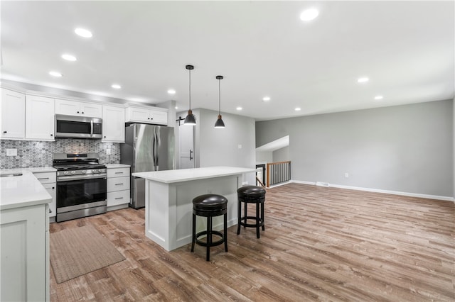 117 Heather Dr, Center Twp Bea, PA 15061 - kitchen featuring stainless steel appliances, light wood finished floors, a breakfast bar area, a kitchen island, and backsplash