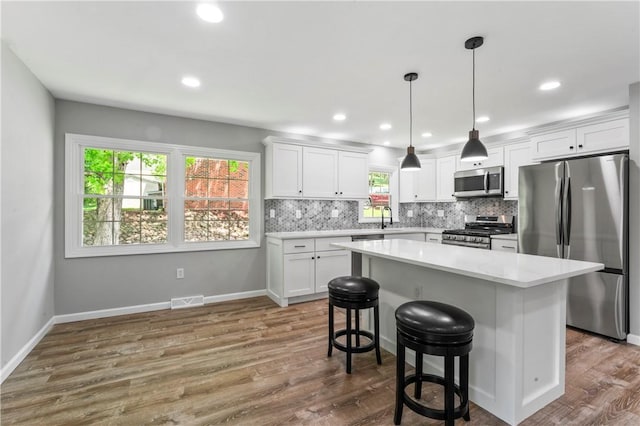 117 Heather Dr, Center Twp Bea, PA 15061 - kitchen featuring stainless steel appliances, light countertops, white cabinets, tasteful backsplash, and dark wood-style flooring