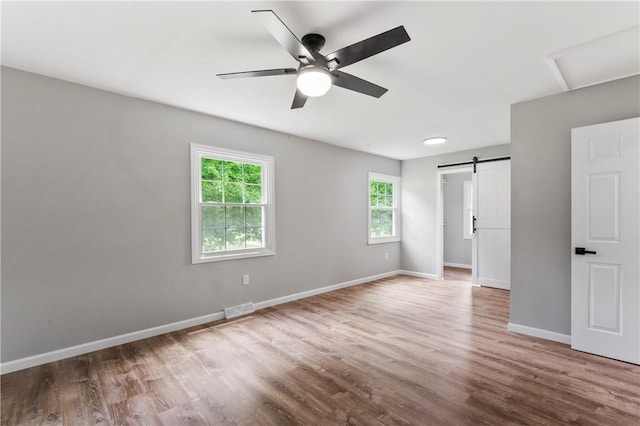 117 Heather Dr, Center Twp Bea, PA 15061 - spare room with wood finished floors, a barn door, ceiling fan, and attic access