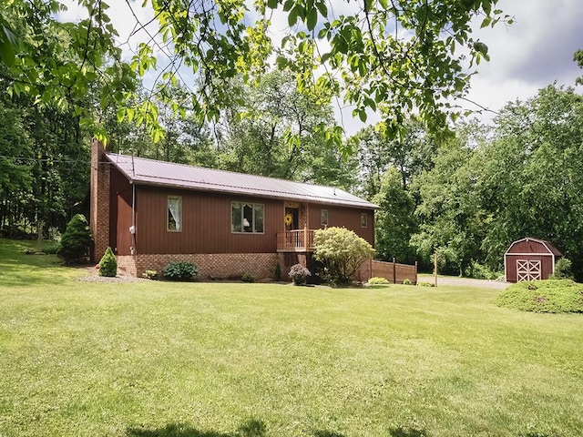 4779 State Route 819, Bell Twp, PA 15613 - view of front of house with a front yard, a storage unit, a chimney, and a metal roof