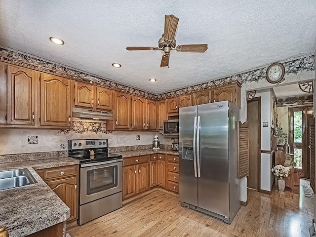 4779 State Route 819, Bell Twp, PA 15613 - kitchen featuring appliances with stainless steel finishes, under cabinet range hood, a ceiling fan, light wood-style flooring, and a textured ceiling
