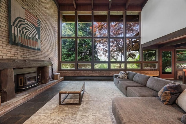 287 Rankin Rd, Belle Vernon, PA 15012 - living room with a wood stove, brick wall, a high ceiling, a wood ceiling with exposed beams, and stone finish flooring