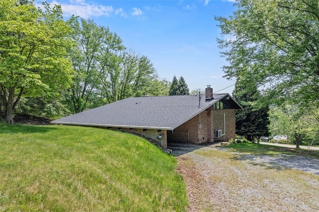 287 Rankin Rd, Belle Vernon, PA 15012 - view of home's exterior with dirt driveway, a chimney, brick siding, and a lawn