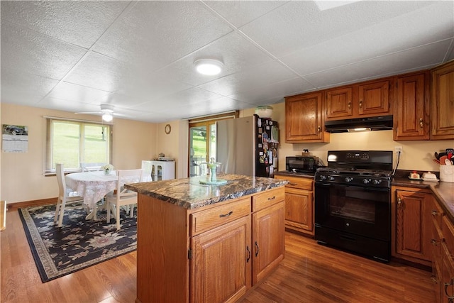 8 Leasure Way, Cecil, PA 15321 - kitchen featuring gas stove, freestanding refrigerator, under cabinet range hood, a kitchen island, and brown cabinets