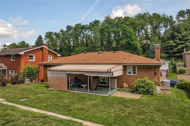4636 Bowes Ave, West Mifflin, PA 15122 - rear view of house featuring a patio, a lawn, a chimney, and brick siding