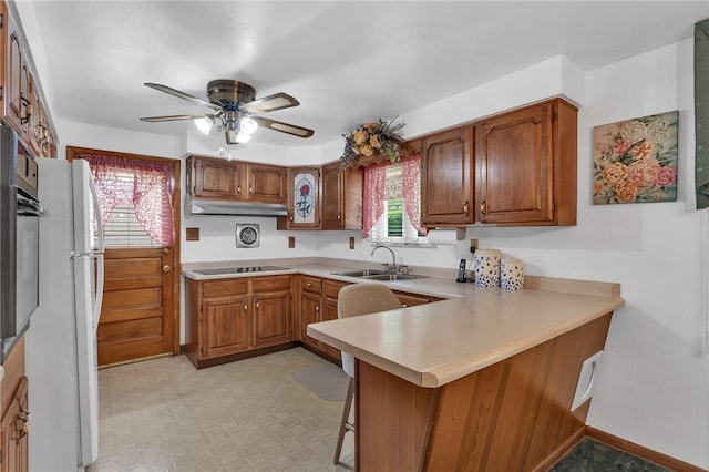 4636 Bowes Ave, West Mifflin, PA 15122 - kitchen with a peninsula, ceiling fan, brown cabinets, and light countertops
