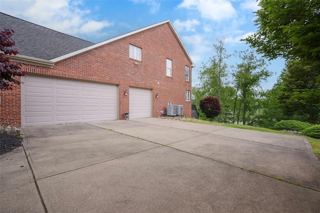 1011 Lakeside Dr, Mount Pleasant Twp Was, PA 15057 - view of property exterior with brick siding, driveway, roof with shingles, and an attached garage
