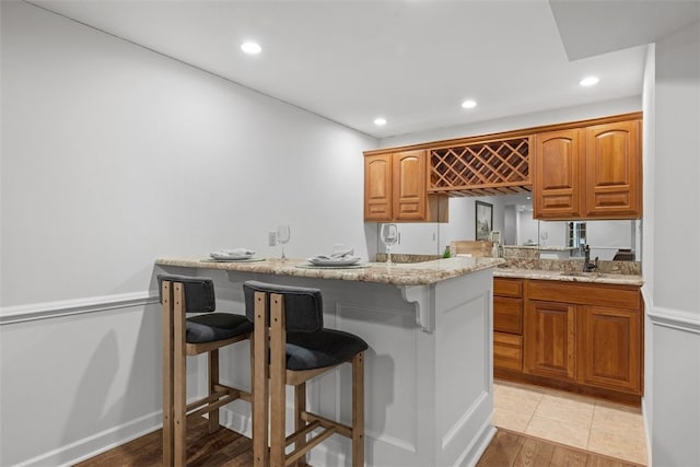 1011 Lakeside Dr, Mount Pleasant Twp Was, PA 15057 - kitchen featuring a kitchen bar, recessed lighting, light wood-style floors, light stone countertops, and a peninsula