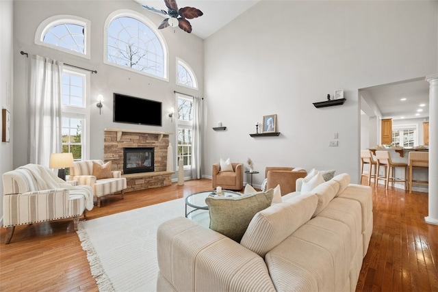 1011 Lakeside Dr, Mount Pleasant Twp Was, PA 15057 - living room featuring high vaulted ceiling, a ceiling fan, a stone fireplace, and wood-type flooring
