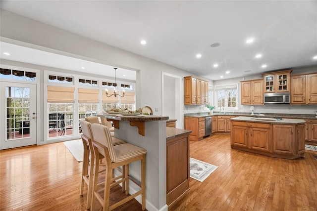 1011 Lakeside Dr, Mount Pleasant Twp Was, PA 15057 - kitchen with stainless steel appliances, a center island with sink, a breakfast bar, light wood finished floors, and recessed lighting