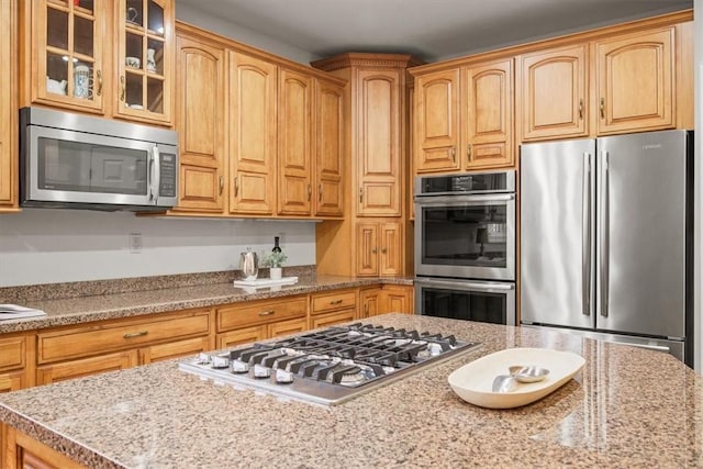 1011 Lakeside Dr, Mount Pleasant Twp Was, PA 15057 - kitchen featuring appliances with stainless steel finishes, glass insert cabinets, and light stone counters