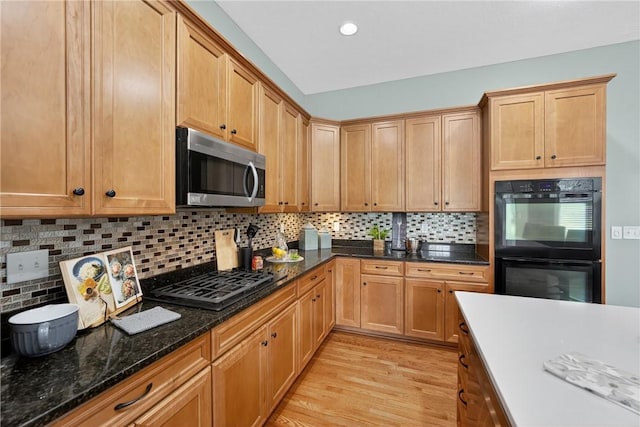 201 Venango Trl, Marshall, PA 16046 - kitchen with stainless steel microwave, gas stovetop, light wood-type flooring, decorative backsplash, and dark stone countertops
