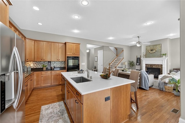 201 Venango Trl, Marshall, PA 16046 - kitchen featuring stainless steel fridge with ice dispenser, a ceiling fan, light wood finished floors, a high end fireplace, and backsplash