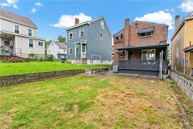 103 Church Ave, Mount Oliver, PA 15210 - rear view of property featuring a lawn, brick siding, covered porch, and a residential view