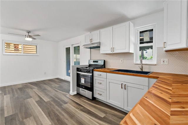 103 Church Ave, Mount Oliver, PA 15210 - kitchen featuring butcher block counters, stainless steel range oven, under cabinet range hood, tasteful backsplash, and white cabinets