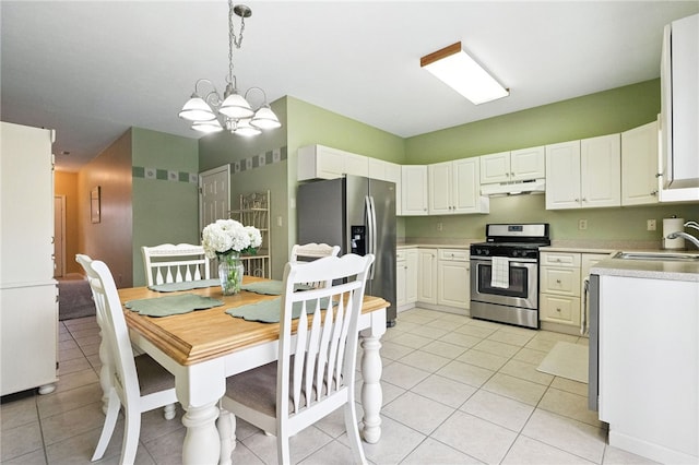 31 Elena Ave, Lower Burrell, PA 15068 - kitchen with appliances with stainless steel finishes, under cabinet range hood, light countertops, light tile patterned flooring, and a chandelier