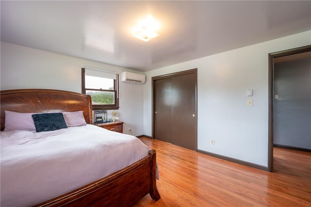 206 Bonnie St, Rostraver, PA 15012 - bedroom with a wall unit AC, a closet, and light wood-style flooring