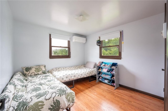 206 Bonnie St, Rostraver, PA 15012 - bedroom featuring an AC wall unit, wood finished floors, and multiple windows