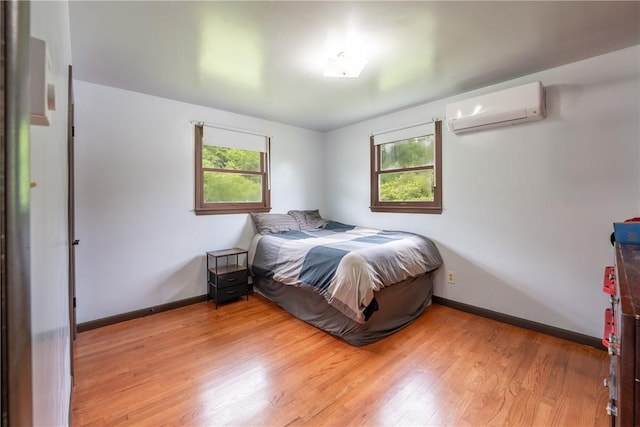 206 Bonnie St, Rostraver, PA 15012 - bedroom with a wall mounted air conditioner, multiple windows, and light wood finished floors