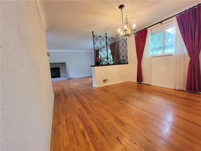 1176 Colgate Dr, Monroeville, PA 15146 - unfurnished dining area with a chandelier, wood finished floors, and a brick fireplace