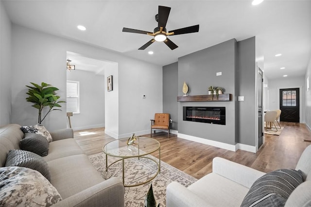 141 Blackhawk St, Squirrel Hill, PA 15218 - living room with healthy amount of natural light, wood finished floors, a glass covered fireplace, ceiling fan, and recessed lighting