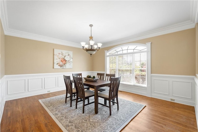 8010 Sherwood Dr, Collier Twp, PA 15142 - dining space featuring a chandelier, crown molding, wood finished floors, and a wainscoted wall