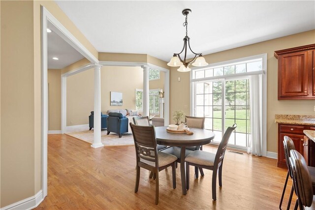 8010 Sherwood Dr, Collier Twp, PA 15142 - dining space featuring ornate columns, light wood finished floors, and a chandelier